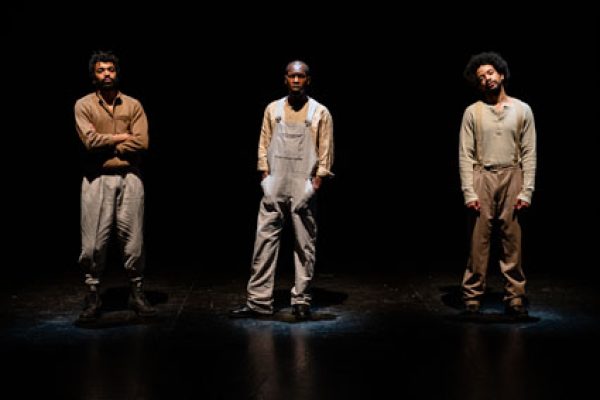 tre attori di colore in piedi in scena