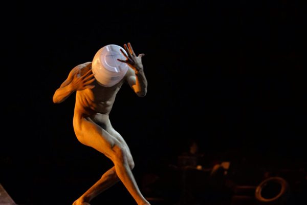 danzatore nudo con la testa coperta da un secchio di lastica